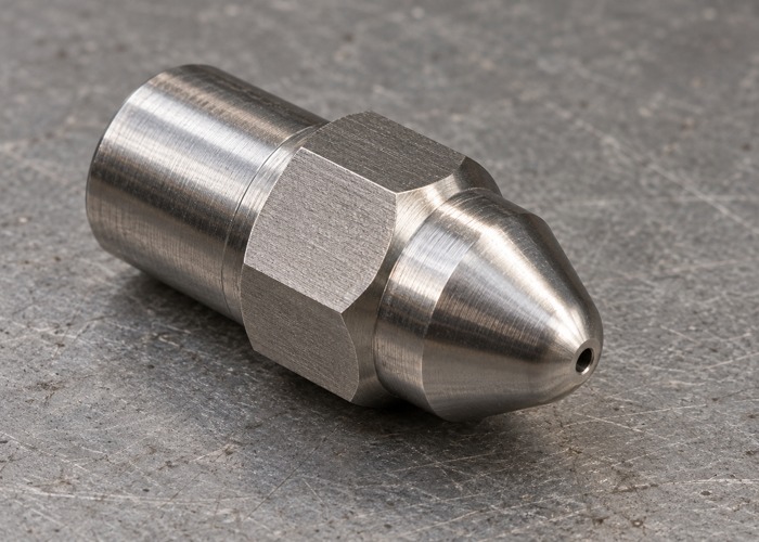 Machined steel nozzle tip with a centered exit opening