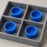 Four blue plastic caps separated in a compartment tray