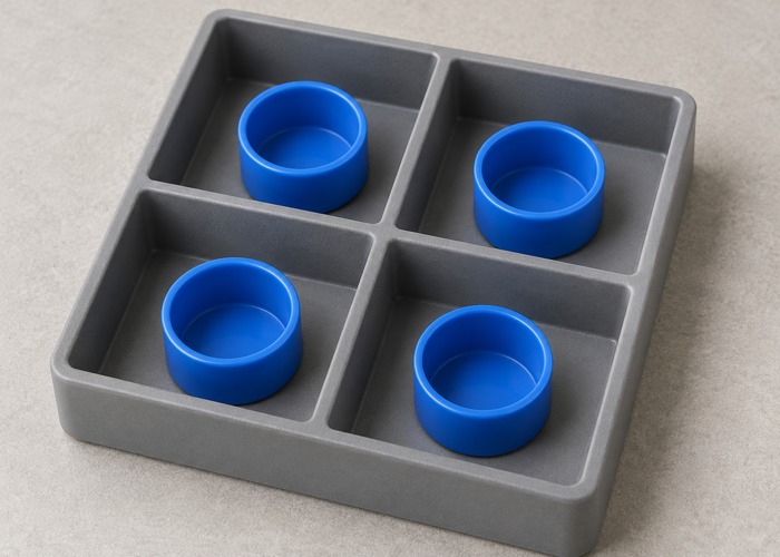 Four blue plastic caps separated in a compartment tray