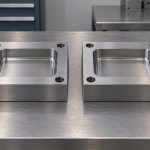 Two separate steel inserts with recessed rectangular cavities