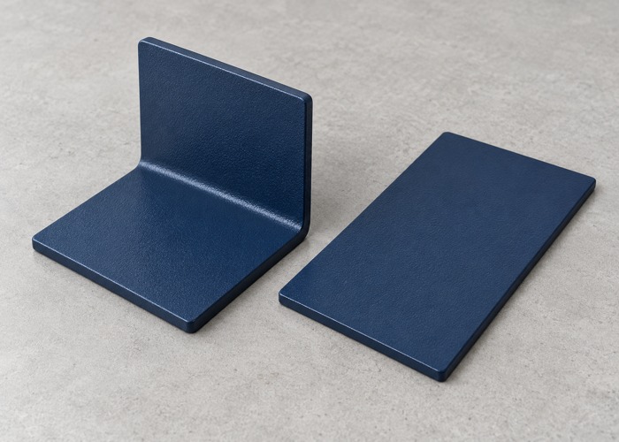 Blue coated bent bracket beside a matching flat sample panel