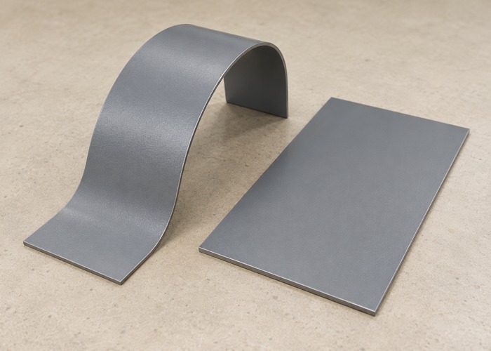 Curved gray coated sheet beside a separate flat panel